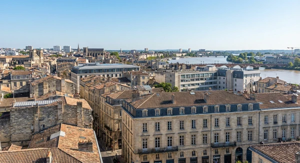 Photographie r&eacute;elle d'un paysage urbain et architectural de Bordeaux en Gironde montrant les b&acirc;timents caract&eacute;ristiques de la ville, les toitures vari&eacute;es et le tissu urbain, capturant l'essence du territoire d'intervention de l'entreprise d'&eacute;tanch&eacute;it&eacute; et de bardage. La photo doit &ecirc;tre prise de mani&egrave;re &agrave; montrer clairement l'architecture et l'environnement urbain bordelais, distinct d'une simple vue a&eacute;rienne.