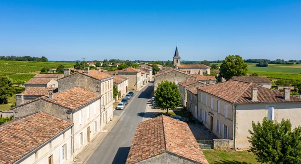 Photographie r&eacute;elle du centre-bourg de Beychac-et-Caillau en Gironde montrant le patrimoine architectural local, les b&acirc;timents typiques de la commune et l'environnement urbain/rural caract&eacute;ristique. La photo doit &ecirc;tre prise &agrave; l'&eacute;chelle du b&acirc;ti ou du paysage urbain pour illustrer clairement le si&egrave;ge et la base d'intervention de MGE, distincte des vues urbaines de Bordeaux et Libourne d&eacute;j&agrave; s&eacute;lectionn&eacute;es. L'image peut inclure des r&eacute;sidences, des &eacute;l&eacute;ments architecturaux locaux ou des voiries caract&eacute;ristiques du territoire, capturant l'identit&eacute; visuelle de cette commune de Gironde.