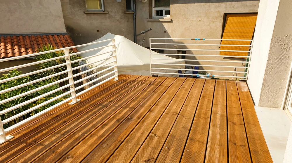 Main de professionnel tenant une loupe devant une villa moderne contemporaine avec terrasse dallée, façade mixte brique et verre, baies vitrées coulissantes et espaces verts paysagers